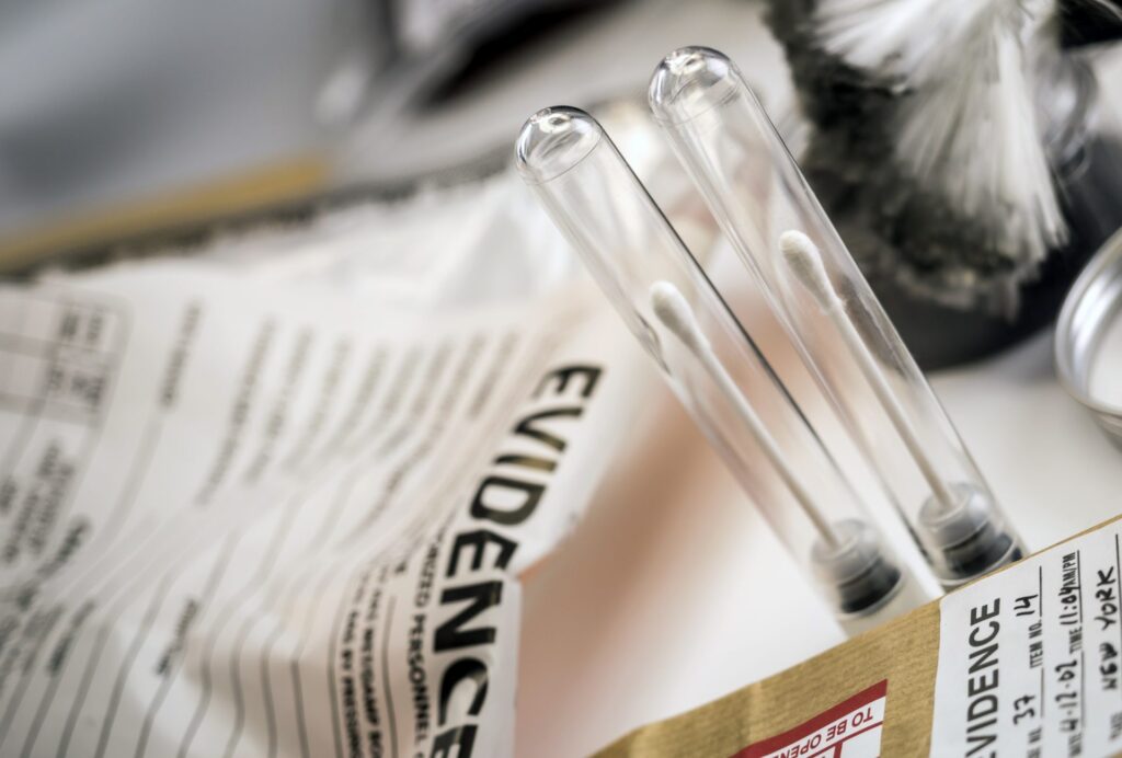 Two tubes with a cotton swab each and a bag that says evidence, representing how one can benefit from calling a Portland criminal defense attorney.
