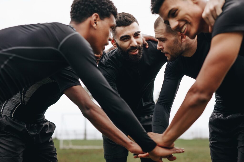 A group of men talking a circle, they are wearing black sportswear. Representing how one can benefit from calling a Portland criminal defense attorney.