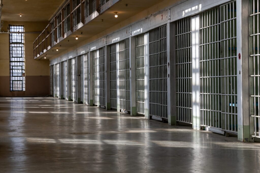 A prison hallway where several cells are visible during the daytime, representing how one can benefit from calling a Portland criminal defense attorney.