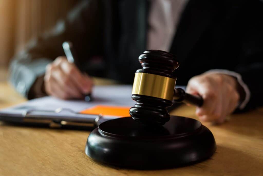 A judge hitting a block with a gavel while sitting on a desk, representing how one can benefit from calling a Portland criminal defense lawyer.