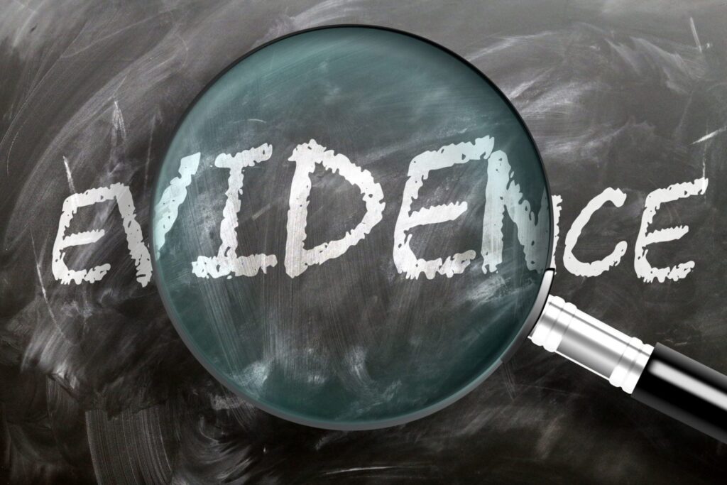 The word "Evidence" and a magnifying glass focusing on it. Representing how one can benefit from calling a Portland criminal defense attorney.