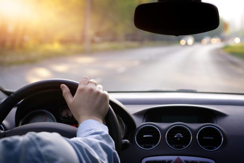 A man driving a car in a clear road, representing how one can benefit from calling a Portland criminal defense attorney.