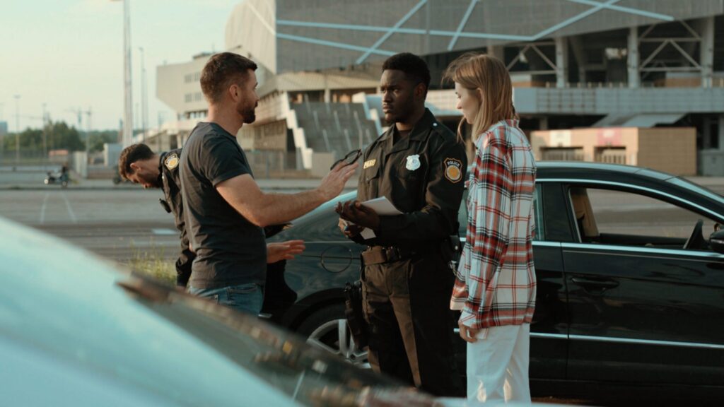 Two people talking to a police office in the street, representing how one can benefit from calling a Portland criminal defense lawyer.