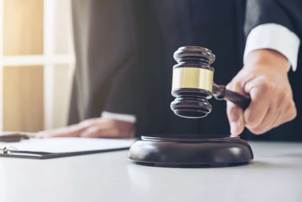 A judge about to hit a block with a gavel, representing how one can benefit from calling a Portland criminal defense lawyer.