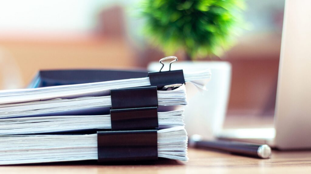 A pile of several documents on a desk, representing how one can benefit from calling a Portland criminal defense attorney.