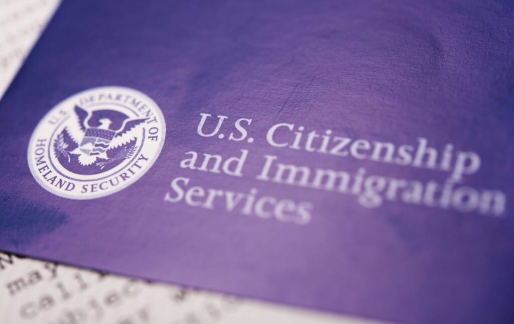 A blue pamphlet that says "U.S. Citizenship and Immigration Services", representing how one can benefit from calling a Portland criminal defense lawyer.