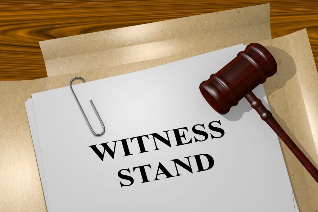 A judge's gavel on top of a folder with a sheet of paper that says "Witness Stand", representing how one can benefit from calling a Portland criminal defense lawyer.