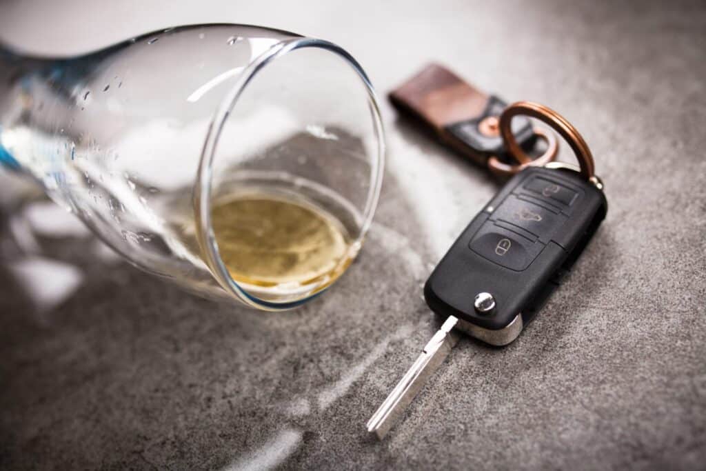 A set of car keys next to a beer glass tipped on its side, representing how one can benefit from calling a Portland criminal defense lawyer.