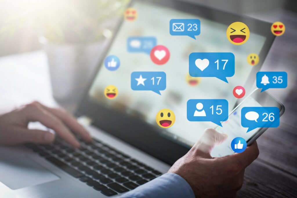 A person with an open laptop, we can see several emojis and social media icons, representing how one can benefit from calling a Portland criminal defense lawyer.