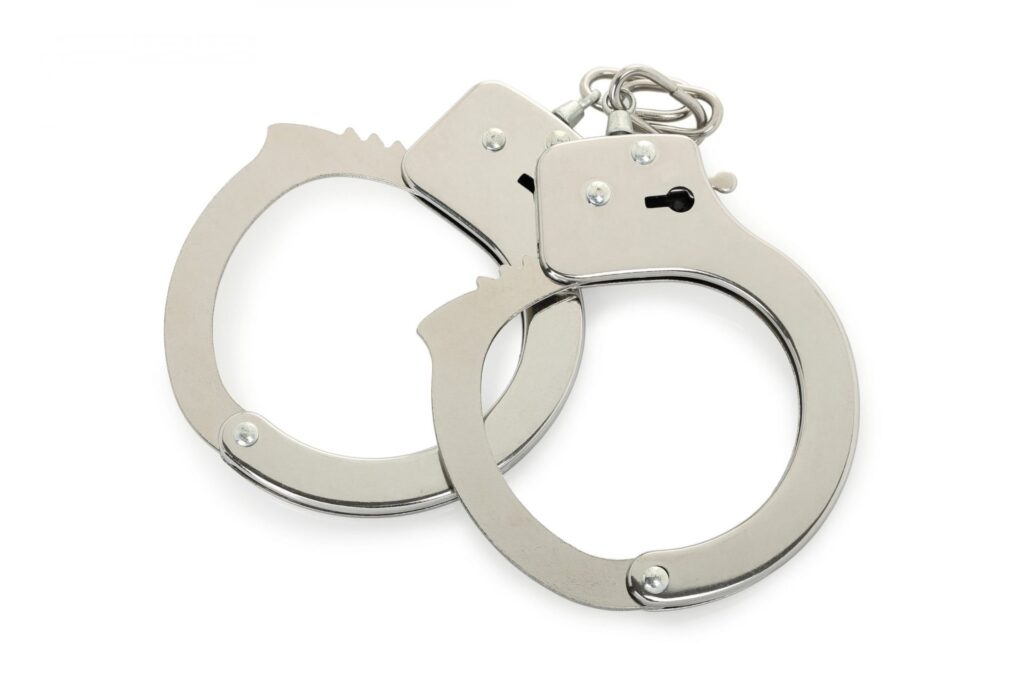 A set of handcuffs over a white background, representing how one can benefit from calling a Portland criminal defense lawyer.