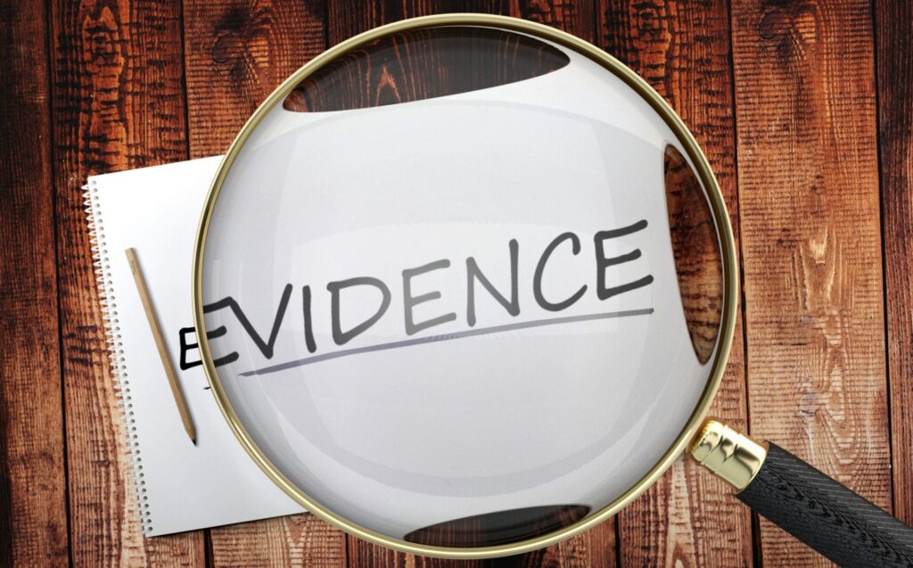 A paper that says the word "Evidence" and a magnifying glass focusing on the word, representing how one can benefit from calling a Portland criminal defense lawyer.