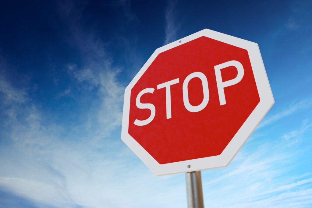 A traffic stop sign, with a beautiful sky background, representing how one can representing how one can benefit from calling a Portland criminal defense lawyer.