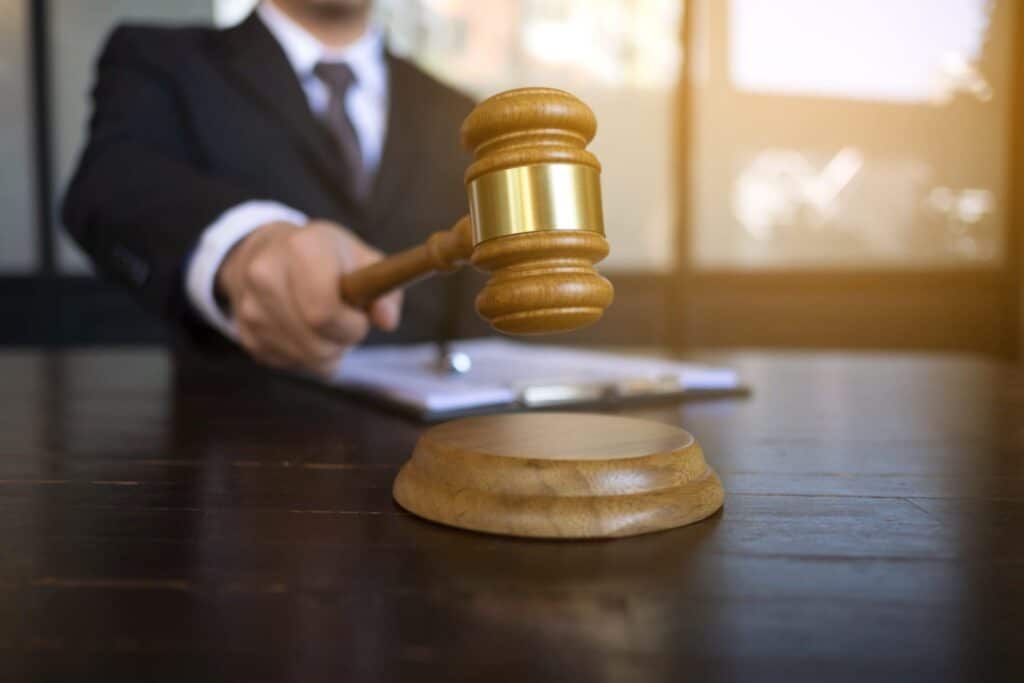 A judge hitting a block with a gavel, representing how one can benefit from calling a Portland criminal defense lawyer.