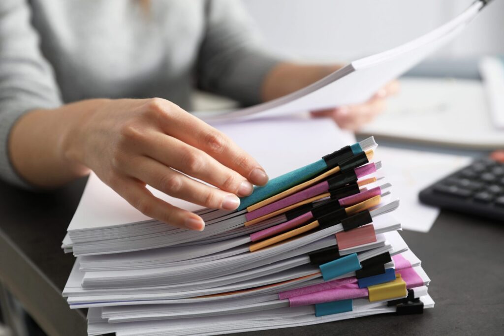 A women with different piles of papers organized, representing how one can benefit from calling a Portland criminal defense lawyer.