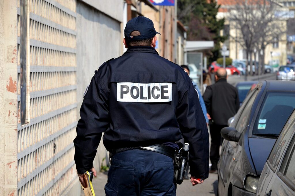 A policeman walking towards other people representing how one can benefit from calling a Portland criminal defense lawyer.