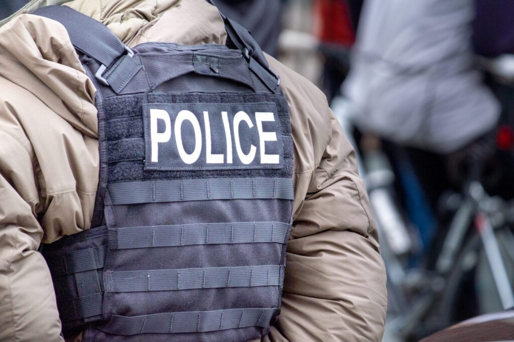 A policeman in the street wearing a vest, representing how one can benefit from calling a Portland criminal defense lawyer.