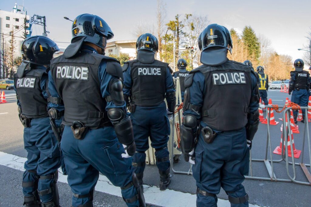 Four policemen standing in the street, representing how one can benefit from calling a Portland criminal defense lawyer.