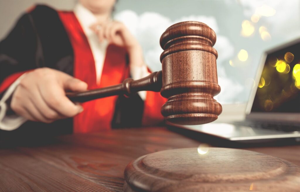 A judge hitting a block with a gavel, representing how one can benefit from calling a Portland criminal defense lawyer.