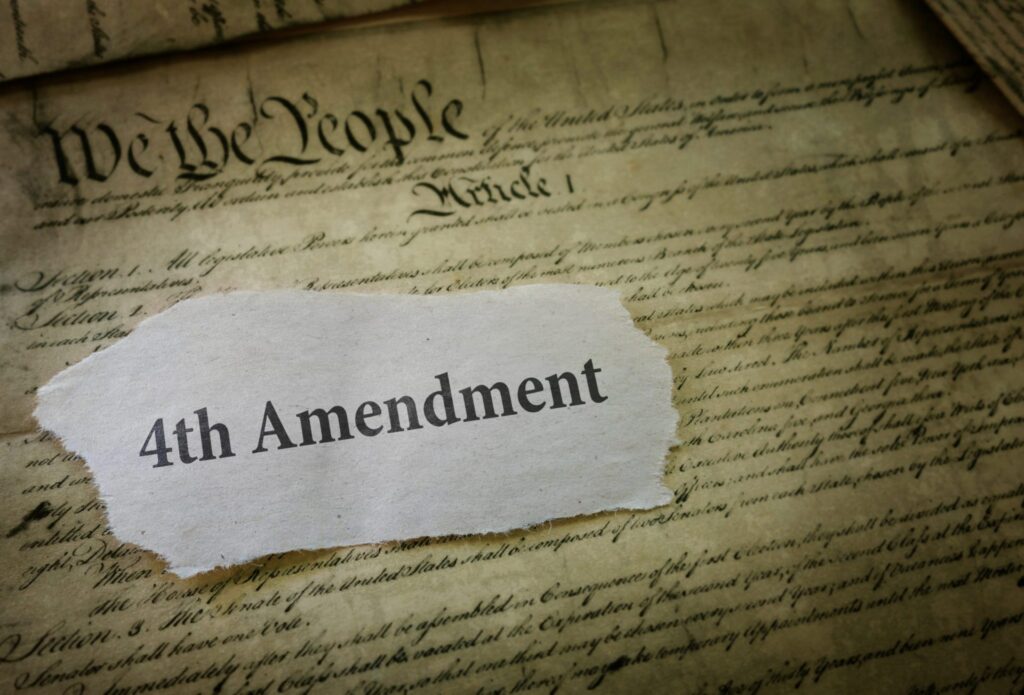 A piece of paper that says "4th Amendment" and the first page of the Constitution in the background, representing how one can benefit from calling a Portland criminal defense lawyer.