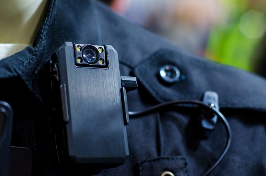 A police officer with a body camera attached to his uniform, representing how one can benefit from calling a Portland criminal defense lawyer.
