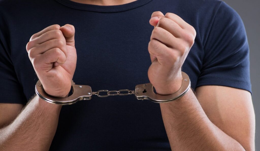 A man wearing handcuffs wearing a dark shirt, representing how one can benefit from calling a Portland criminal defense lawyer.