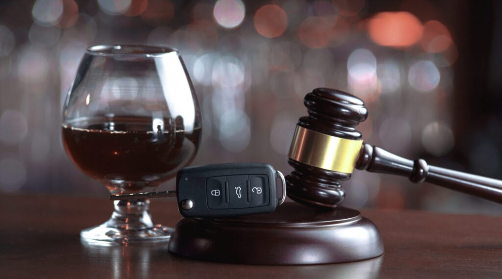 A judge's gavel with a set of car keys and an alcoholic beverage next to them, representing how one can benefit from calling a Portland criminal defense lawyer.