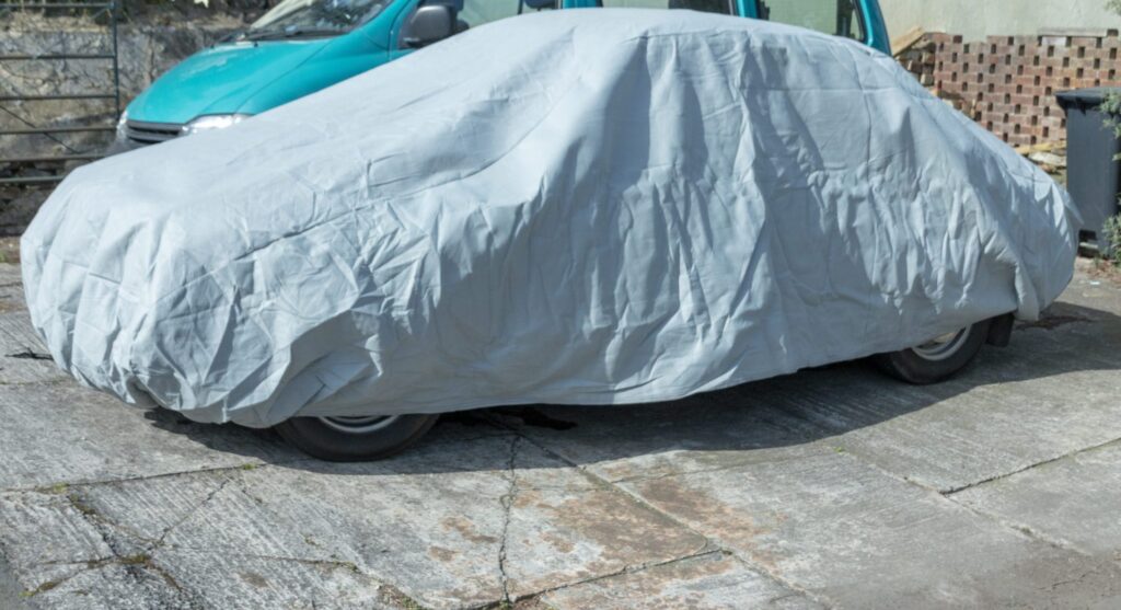 A covered car parked in a driveway, representing how one can benefit from calling a Portland criminal defense lawyer.