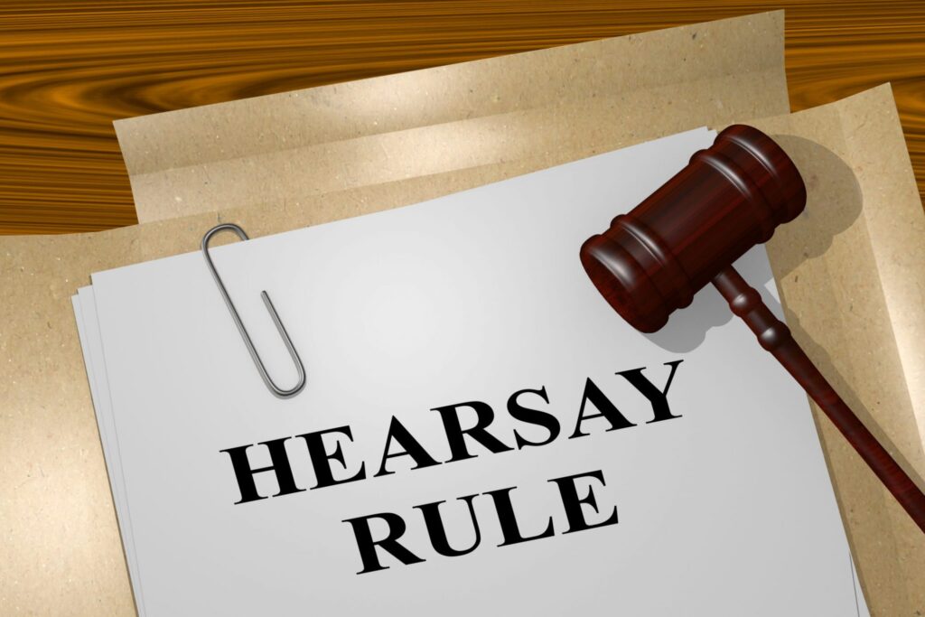 A piece of paper on a clip that say "Hearsay Rule" and a judge's gavel, representing how one can benefit from calling a Portland criminal defense lawyer.