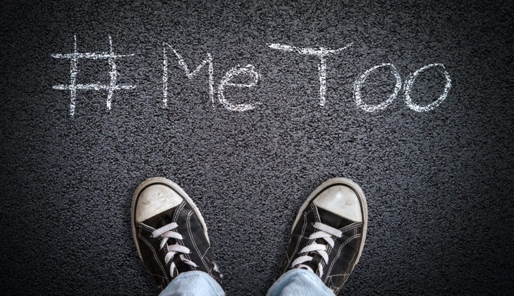 A person's shoes on the street, with chalk it is written on the concrete "#me too", representing how one can benefit from calling a Portland criminal defense lawyer.