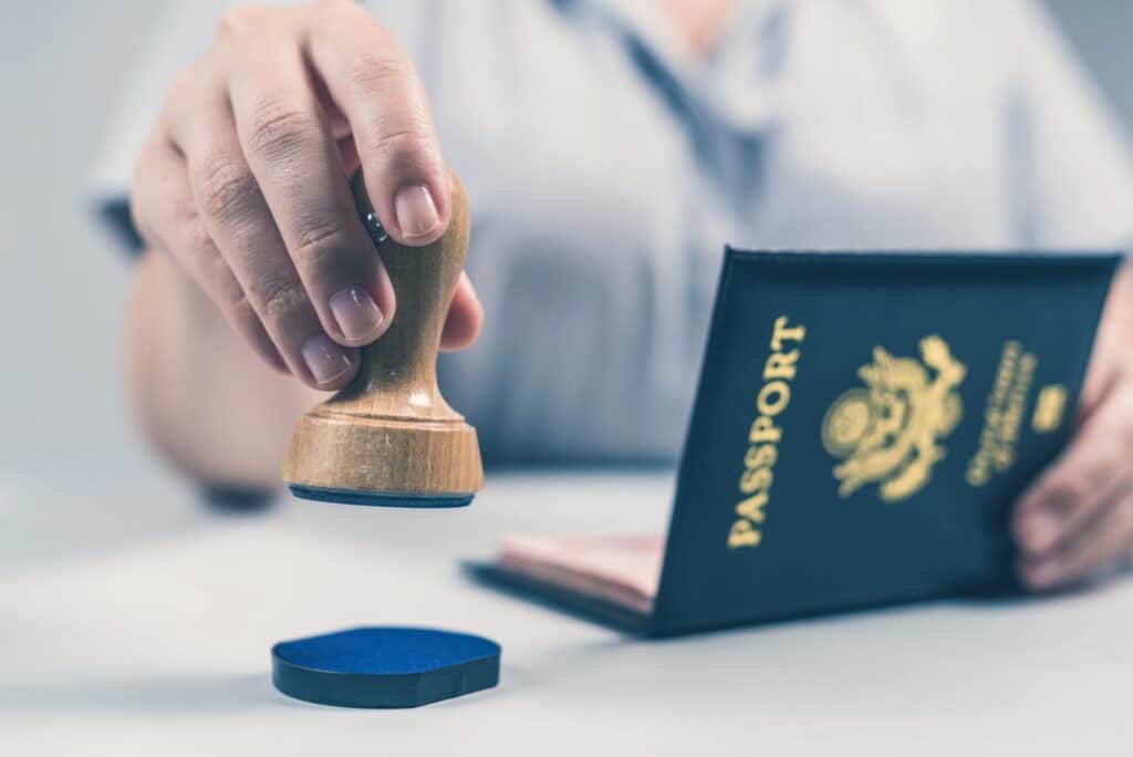 A worker stamping a passport, representing how one can benefit from calling a Portland criminal defense lawye.