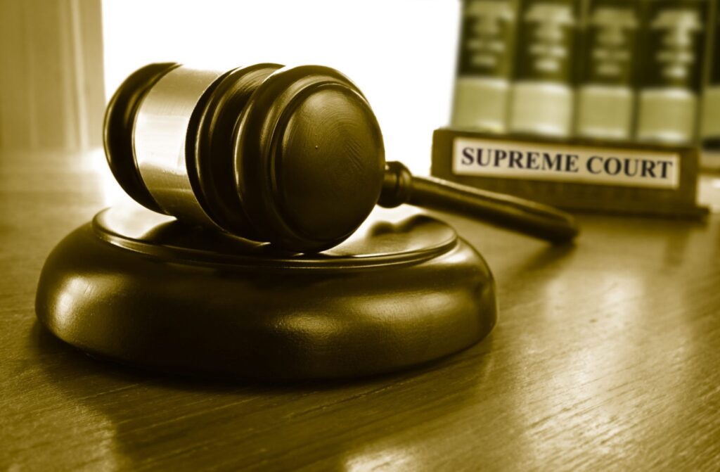 A judge's gavel and the words "Supreme Court" in the background, representing how one can benefit from calling a Portland criminal defense lawyer.