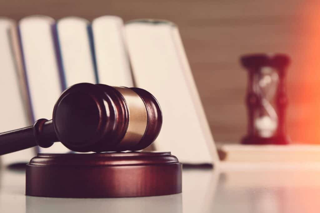 A judge's gavel with books and an hour glass in the back, representing how one can benefit from calling a Portland criminal defense lawyer.