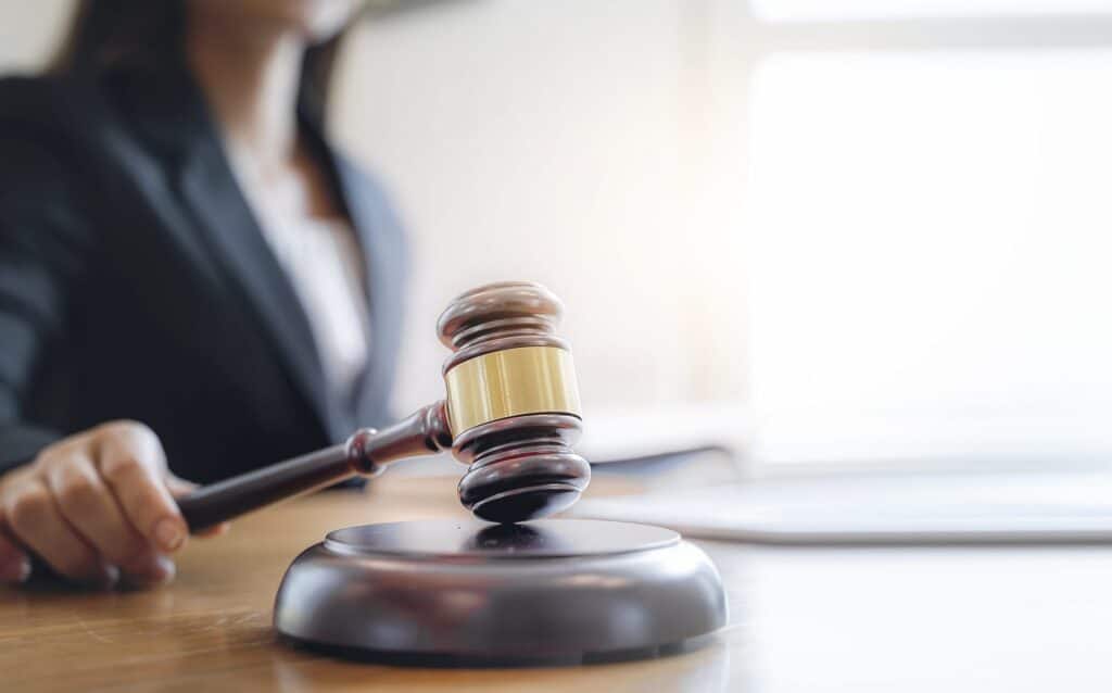 A judge hitting a block with a gavel, representing how one can benefit from calling a Portland criminal defense lawyer.