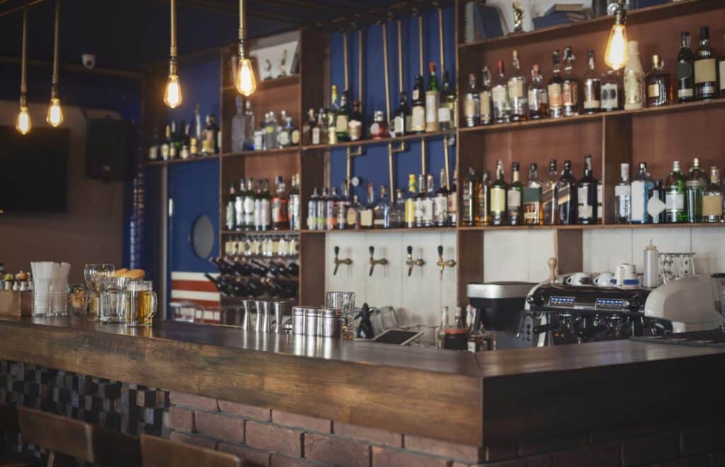 A restaurant bar with many liquor bottles and draft beer, representing how one can benefit from calling a Portland criminal defense lawyer.