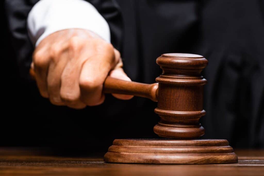 A judge hitting a block with a gavel, representing how one can benefit from calling a Portland criminal defense lawyer.