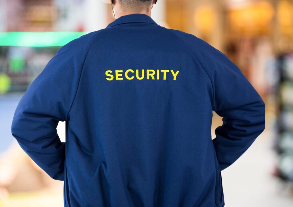 A man wearing a security uniform jacket that says "Security" representing how one can benefit from calling a burglary attorney in Sanford.