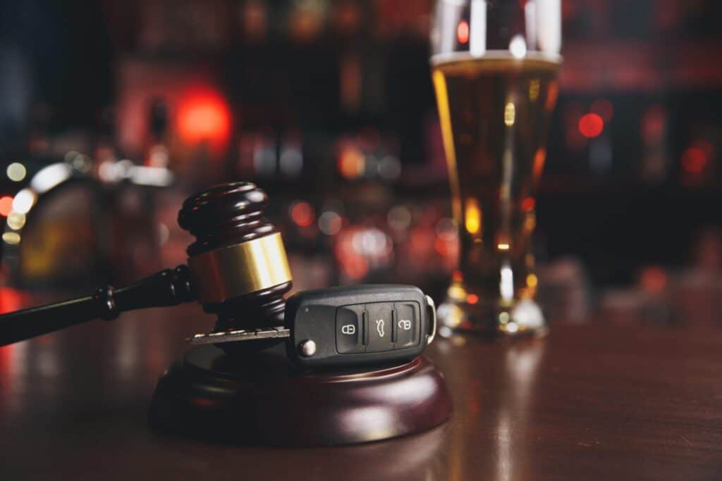 A picture of a glass of beer, a set of car keys and a judge's gavel, representing how one can benefit from calling a Maine criminal defense lawyer.