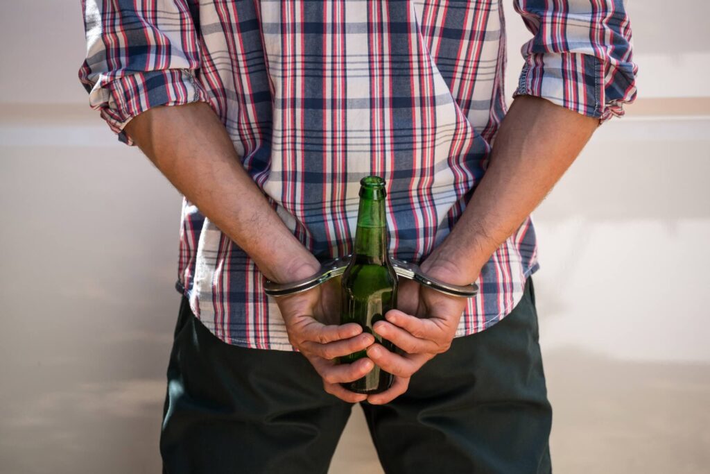 How a DUI Conviction Can Affect Your Life represented by a man hiding a beer behind his back