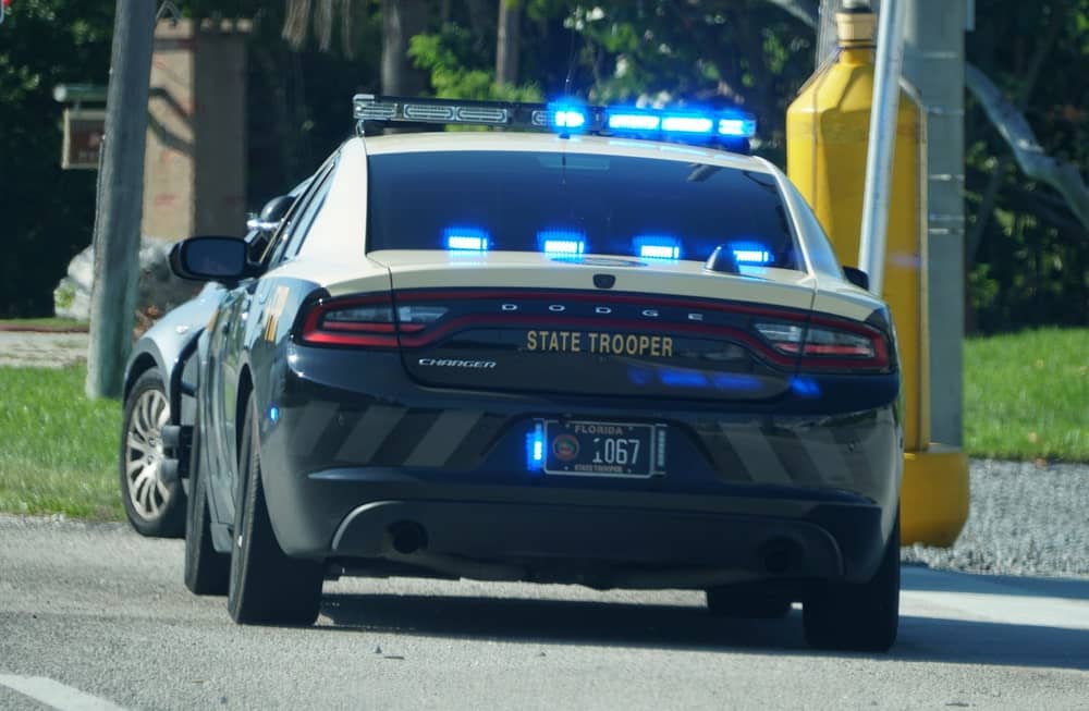 Driving on a Suspended License Defense Lawyers in Maine portrayed by a police car pulling over a driver