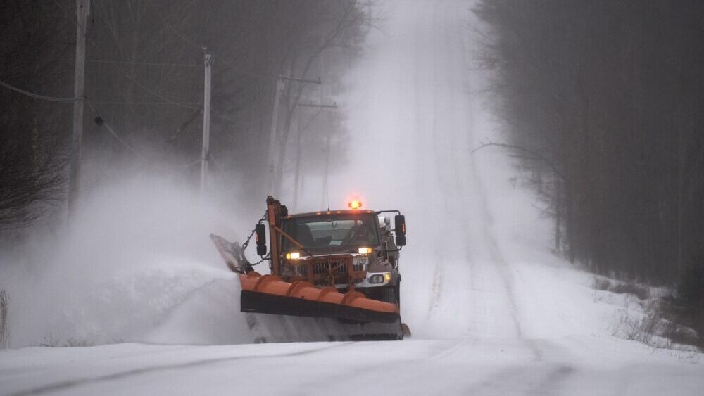 Skowhegan Woman Charged with OUI After Head-On Collision with Maine DOT Plow Truck depicted by a Maine snow plow removing snow on country road
